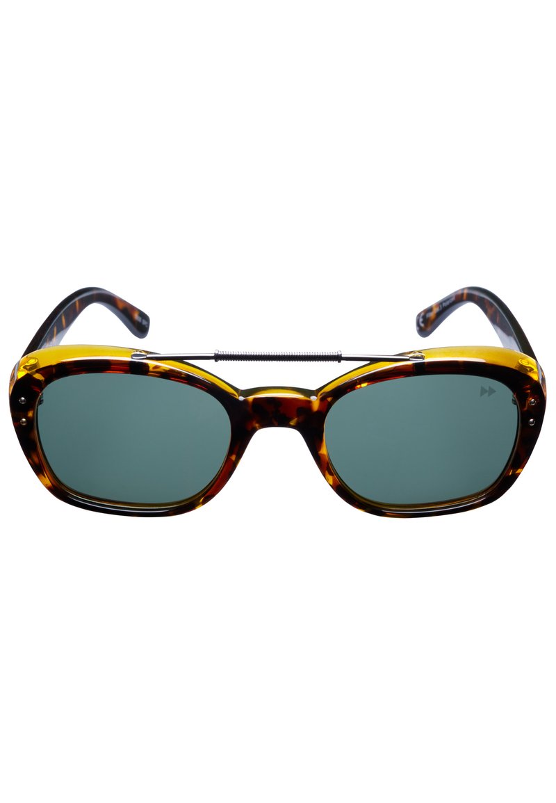 Skalögon med sköldpaddsmönster och gröna linser, fyrkantiga bågar och metallaccenter som kopplar samman linserna. Glänsande yta, robust konstruktion.