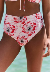 Vrchný diel bikín s vysokým pásom z elastickej tkaniny. Má kvetinový vzor v červenej a ružovej farbe s čiernymi akcentmi. Hladká textúra.