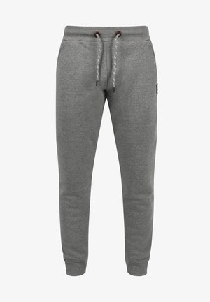 Grå joggebukser laget av myk bomull, med snor som kan justeres i midjen og kontrasterende detaljer, samt slanke, smale ben.