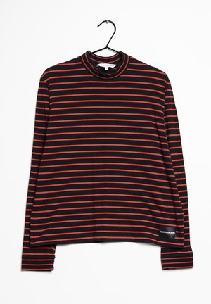 Černé tričko s dlouhým rukávem s tenkými červenými vodorovnými pruhy, vysokým límcem a malým bílým logem "Calvin Klein Jeans" na spodní přední straně.