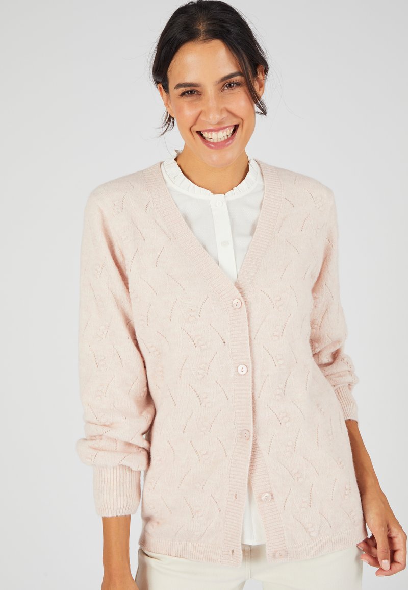 Cardigan rosa chiaro con un motivo di lavorazione a maglia testurizzata, scollo a V e cinque bottoni. Maniche arrotolate e orlo a coste aggiungono dettagli al design.
