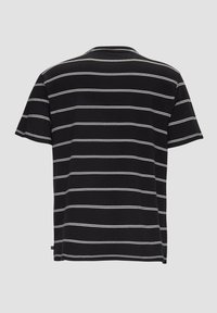Zwarte T-shirt met witte horizontale strepen, korte mouwen en een ronde hals. Gemaakt van zachte stof met een relaxte pasvorm. Geen zichtbare merknaam.