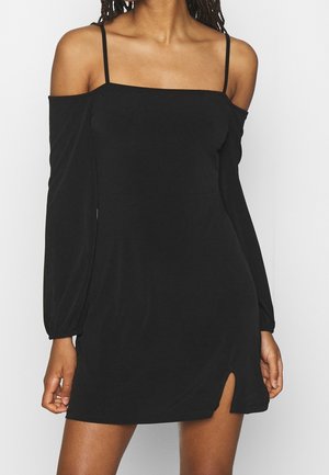 Czarna sukienka na jedno ramię z długimi rękawami, kwadratowym dekoltem i rozcięciem z boku. Wykonana z gładkiego, lekkiego materiału o dopasowanym kroju.