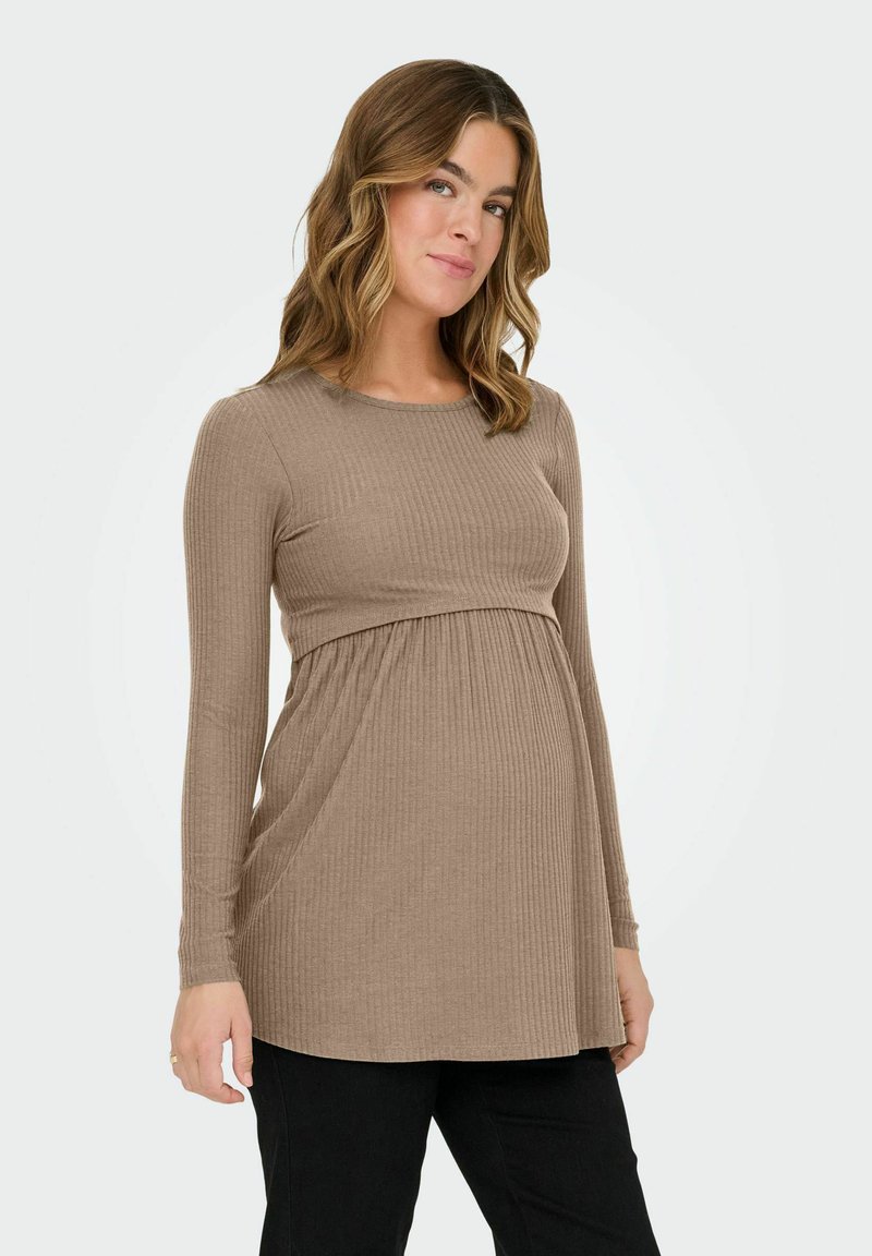 Μακρυμάνικη μπλούζα εγκυμοσύνης από ριπ ύφασμα σε καφέ απόχρωση, με σούρες στη μέση για χαλαρή εφαρμογή. Συνδυάζεται με μαύρο παντελόνι.