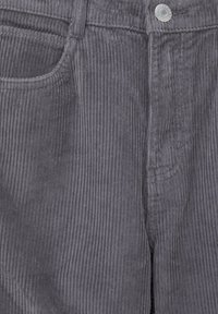 Pantalons en velours côtelé gris avec une texture à côtes verticales, design à cinq poches et fermeture à bouton en métal. Tissu lisse, coupe mi-haute.