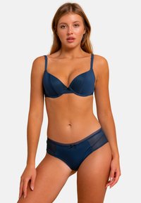 Soutien-gorge bleu marine et ensemble de culottes assorties en tissu lisse, présentant des motifs à rayures subtiles, des bordures en dentelle et des accents de nœud.