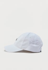 Λευκό καπέλο μπέιζμπολ από βαμβάκι, με κυρτή γείσο και ρυθμιζόμενο λουράκι. Διαθέτει μαύρη κεντητή λογότυπο στο μπροστινό μέρος.