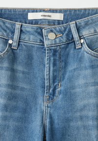 Jeans van licht gewassen denim met een rechte pijp, voorzien van een zilveren knoop, gestikte details en een merklabel aan de binnenkant van de tailleband.