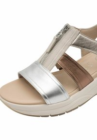 Sandalo open-toe con una fascia frontale metallica argento, accenti marroni e beige, e una cerniera laterale. Suola imbottita per il comfort.