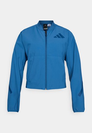 Blaue kurze Jacke mit durchgehendem Reißverschluss, Stehkragen und elastischen Bündchen. Verfügt über zwei horizontale Taschen und ein Logoakzent auf der Brust.