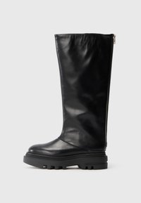 Bota de cuero negra hasta la rodilla con punta redondeada, suela de goma gruesa y cremallera lateral para cierre. Textura suave con un detalle mínimo.