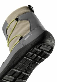 Szare wodoodporne zimowe botki z teksturowaną tkaniną, zielonymi elastycznymi sznurówkami i solidną czarną gumową podeszwą z bieżnikiem.