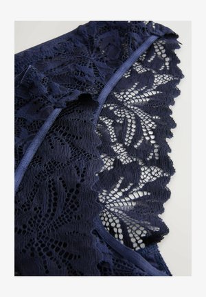 Tessuto in pizzo navy con motivi floreali intricati e bordi scallop, con una texture liscia e un trim solido a contrasto.