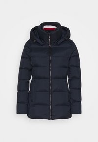 Marinblå vadderad jacka med huva, med en hel dragkedja, quiltat mönster och kontrasterande röd och vit randig foder.