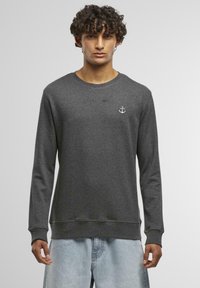 Felpa in cotone grigia con maniche lunghe, caratterizzata da un logo bianco a forma di ancora sul petto e un design a girocollo. Tessuto morbido.