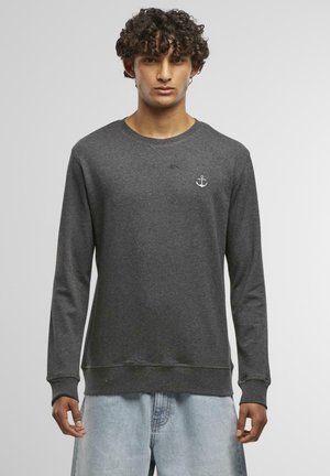 Sweatshirt en coton gris avec manches longues, arborant un logo d'ancre blanche sur la poitrine et un col rond. Texture douce.