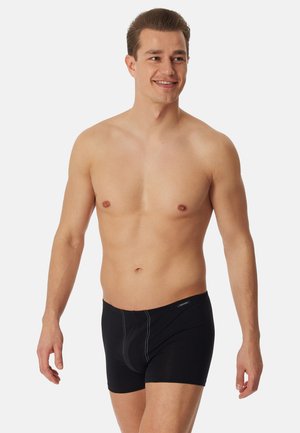 Boxer neri in tessuto morbido, con design aderente, cuciture a contrasto e una cintura elastica. Senza logo visibile.