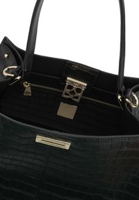 Sort krokodille-embossed læder tote taske med guldfarvet hardware, der har en lynlås indvendig lomme og to top-håndtag.