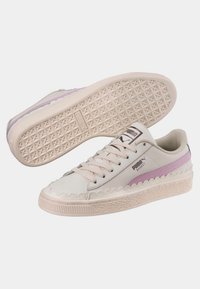 Tenisky Puma Basket v krémové a světle fialové barvě, s hladkým koženým svrškem, vlnkováním a texturovanou gumovou podrážkou.