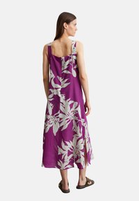 Paarse mouwloze jurk met een wit bloemenpatroon, middellange lengte met zijsplitten, gemaakt van lichtgewicht stof. Eenvoudig, rechthoekig rugontwerp.