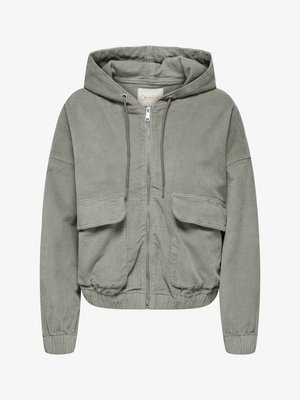 Gaiši zaļš kordūru jaka ar kapuci, elastīgām piedurknēm, divām priekšējām kabatām un priekšējo rāvējslēdzēju. Iezīmējas ar ribotu tekstūru un brīvu piegriezumu.