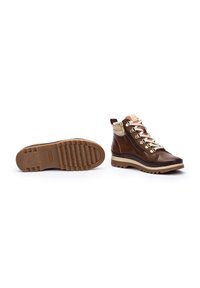 Bottes de randonnée marron et beige avec un design montante, une tige en cuir texturé, des lacets contrastants et une semelle en caoutchouc robuste et à motifs.