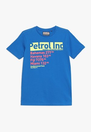 Blaues kurzärmeliges T-Shirt mit mehrfarbigem Text, der Entfernungen zu den Bahamas, Havanna, Fidschi, Miami und Key West auflistet, mit "Petrol Ind" Branding.
