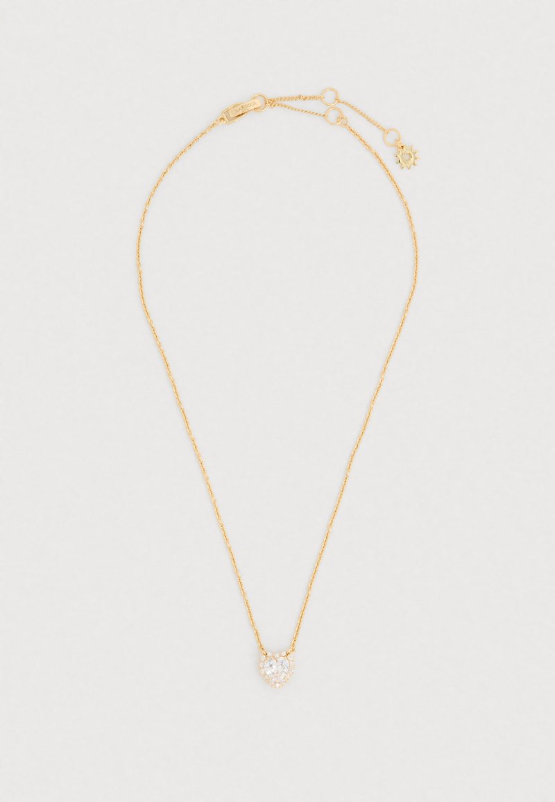 Colier cu ton auriu, având un lanț delicat și un pandantiv în formă de inimă cu o piatră clară centrală înconjurată de accente mai mici.