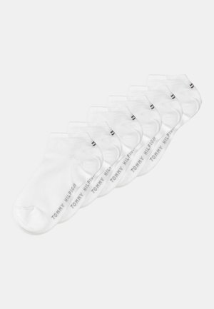 Calzini alla caviglia bianchi in cotone, con una leggera texture a costine. Ogni calzino ha stampato in grigio "TOMMY HILFIGER" lungo il lato.