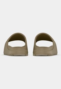 Ταμπά σανδάλια slip-on με ανοιχτή πλάτη, υφή στην επάνω επιφάνεια και επίπεδη, ελαστική σόλα, με μινιμαλιστικό σχέδιο και λεία επιφάνεια.