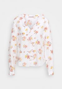 Blouse blanche à fleurs avec des fleurs roses et jaunes, des volants le long de l'encolure et des manches longues. Tissu doux avec une texture légère.