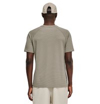 Man draagt een beige kortärmelig textuurhemd, lichte korte broek en een beige pet, gezien van achteren op een witte achtergrond.