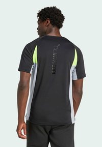 Černé a šedé sportovní tričko s krátkým rukávem a limetkovými akcenty. Na zadní straně má silikonové logo "CLIMACOOL". Měkká, strukturovaná tkanina.