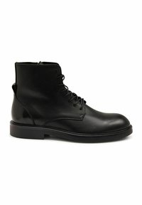 Bottines en cuir noir avec une texture lisse, bout rond et design à lacets. Présentent un talon bas et robuste ainsi que des détails de couture minimaux.