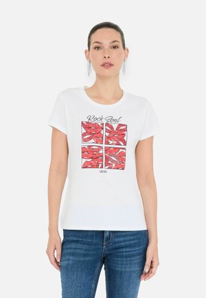 T-shirt bianca in cotone con un design grafico rosso raffigurante delle labbra e il testo "Rock Soul". Collo tondo e maniche corte, abbinata a jeans blu.