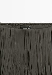 Szara plisowana spódnica z elastycznym pasem. Wykonana z lekkiego materiału. Charakteryzuje się fakturowaną powierzchnią i zawiera metkę "Massimo Dutti".
