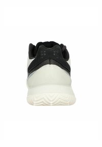 Scarpa sportiva bianca e nera con un tallone testurizzato, parte superiore in tessuto liscio e suola con un motivo. Presenta fori di ventilazione discreti sul retro.