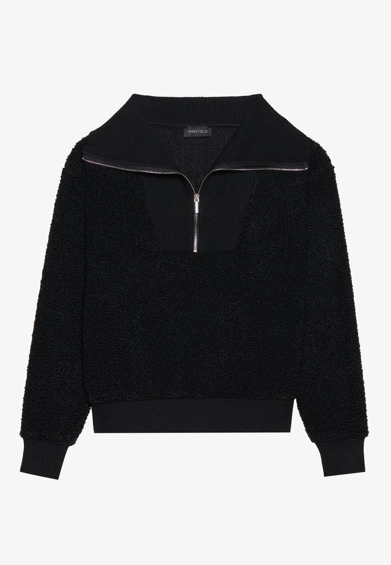 Pull sombre en polaire avec col montant zippé, matière en polaire texturée, poignets et ourlet côtelés, et une couleur noire uniformément répartie.