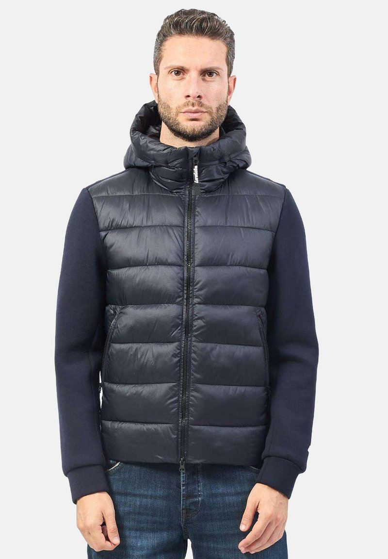Gilet imbottito blu navy con cappuccio, chiusura con zip e maniche a coste blu navy, con una texture liscia e un motivo a righe orizzontali.