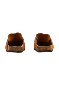 Brune ruskindssko uden snørebånd med en buet hæl, lysfarvet indersål og en tekstureret, mørk gummisål.