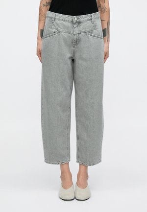 Pantalon en denim gris clair taille haute à coupe ample, avec poches avant et fermeture par bouton. Tissu légèrement texturé.