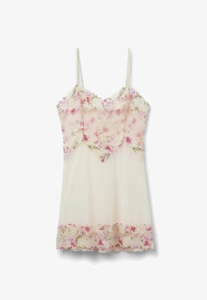 Kremfarvet slip-kjole med lyserødt blomstret blonderoverlæg på bryst og nederkant, med tynde skulderstropper og bølget kant.