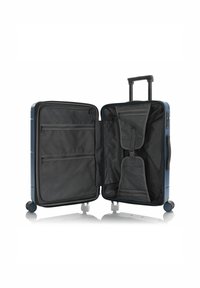 Hardshell suitcase in navy blue with a retractable handle, four wheels, and a black interior featuring mesh pockets and straps for organization.