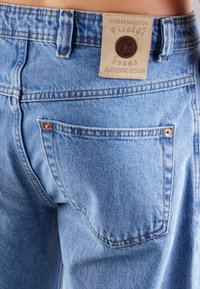 Helle blaue Denim-Jeans mit einem Lederetikett mit der Aufschrift "Picaldi" am Taillenbund, ausgestattet mit Kupferrivets und klassischem Design der Gesäßtaschen.