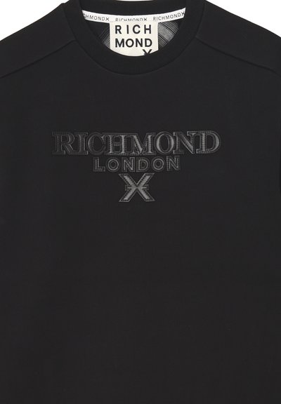Felpa nera con testo in rilievo nero "RICHMOND LONDON X" sul petto e un'etichetta bianca con "RICHMOND" all'interno del colletto.
