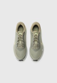 Light green athletic shoes featuring a mesh upper, rounded toe, and textured sole. Accented with a gold logo and flat, matching laces.