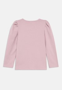 Bluzka z długim rękawem w jasnoróżowym kolorze, wykonana z miękkiej bawełny. Posiada marszczone detale na szwach ramion oraz okrągły dekolt.