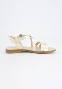 Gullfargede sandaler med flere stropper, flat såle og justerbar spenne på ankelstroppen. Jevn tekstur med et minimalistisk design.