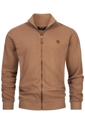 Brun ribbad zip-up jacka med ståkrage, långa ärmar och en liten cirkulär logotyp på bröstet.