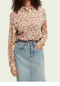 Květinová košile na knoflíky v kombinaci růžových, oranžových a zelených odstínů; dlouhé rukávy; měkká tkanina; v kombinaci s lehkou džínovou sukní.